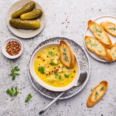 zupa ogórkowa gotowa w talerzu z grzanką